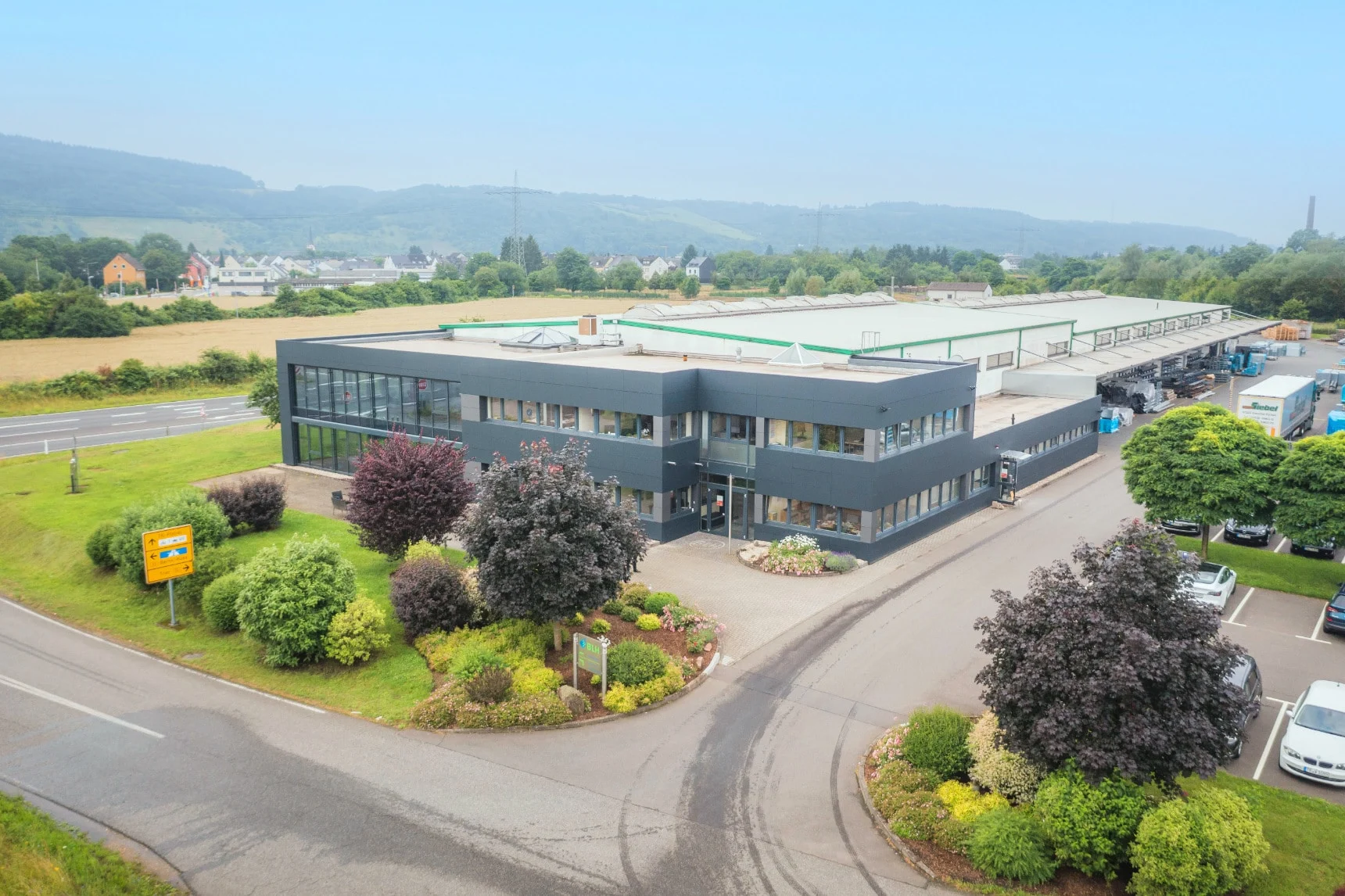 Luftbild des BLH Werks in Trier-Pfalzel mit Produktionshalle, Verwaltung und Parkplatz